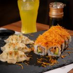 Menú de mediodía en Sudoki Sushi & Fusión en Barcelona con gyozas, sushi roll cubierto de crujiente zanahoria y bebida refrescante