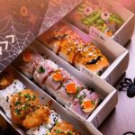 Cajas de sushi edición Halloween de Sudoki Sushi Barcelona con rolls decorados, tempura crujiente, salmón y detalles temáticos de arañas y telarañas.
