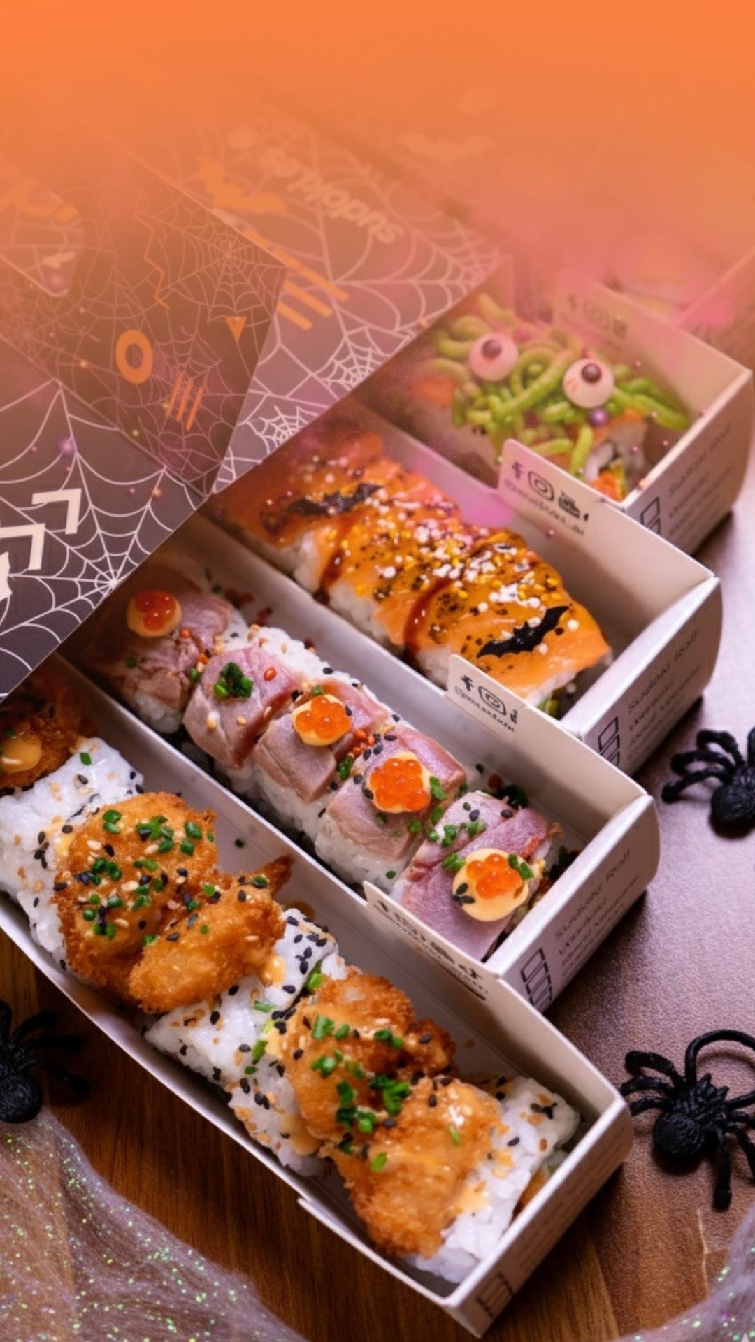 Cajas de sushi edición Halloween de Sudoki Sushi Barcelona con rolls decorados, tempura crujiente, salmón y detalles temáticos de arañas y telarañas.